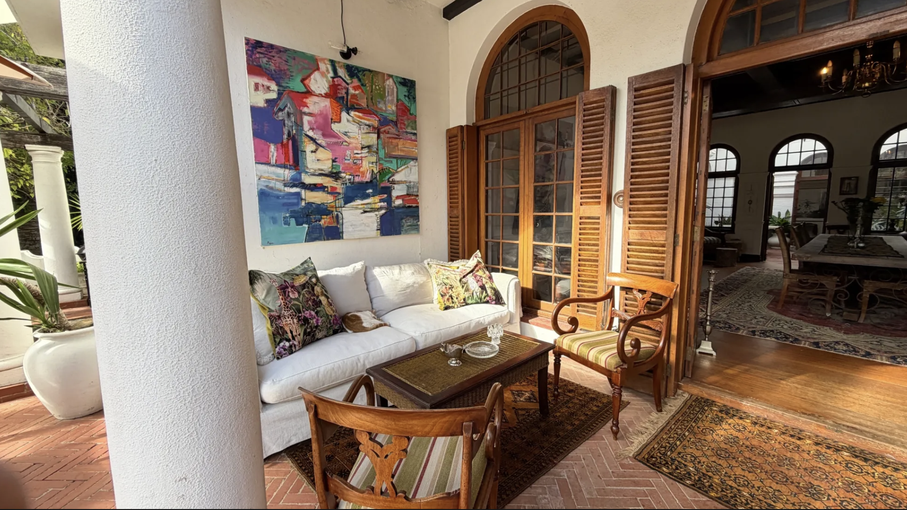 The covered veranda with colourful artwork — indoor-outdoor seating at MANTI