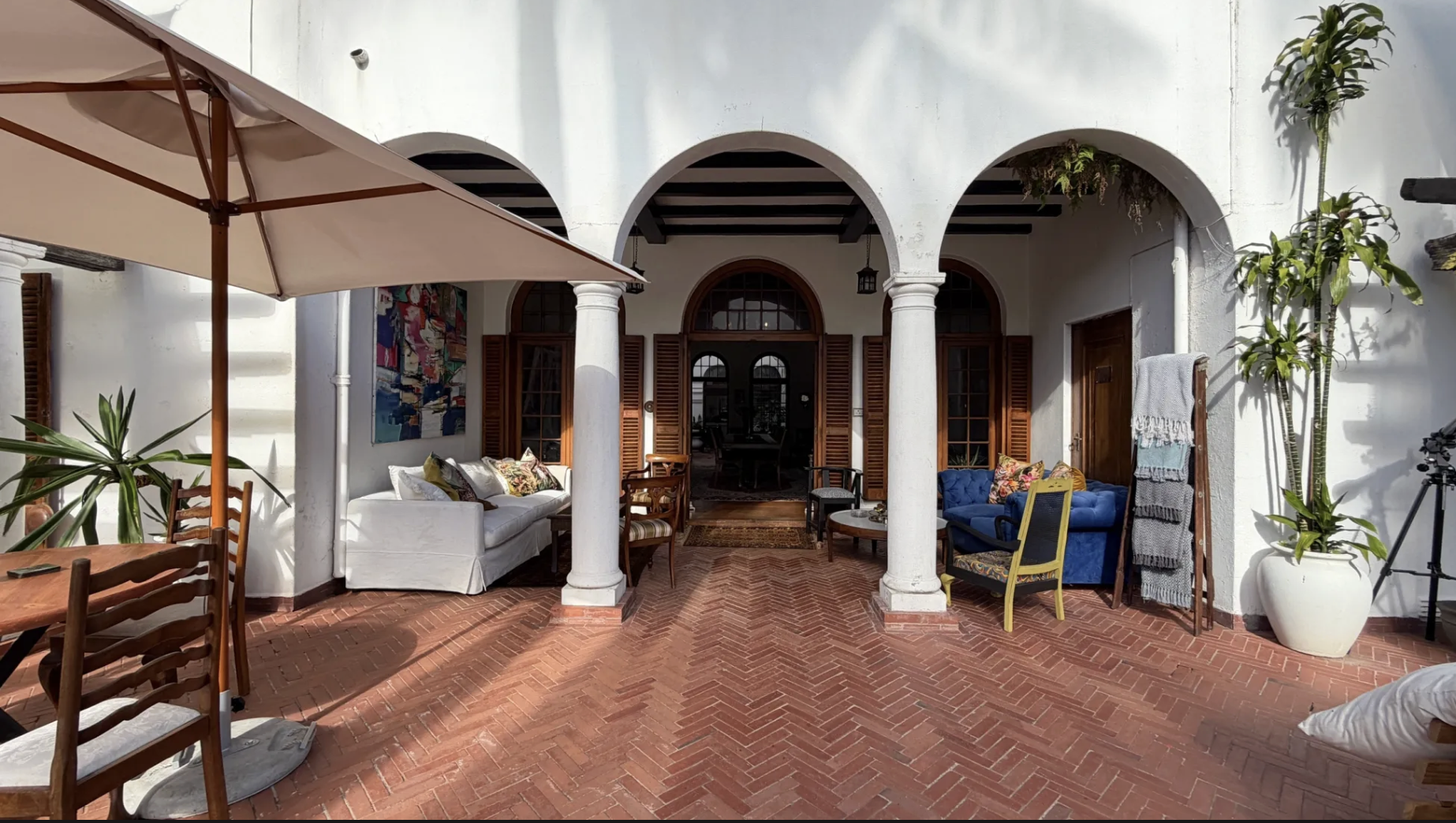 The courtyard at Glenhof Manor — arched columns, terracotta brick floors and lush greenery