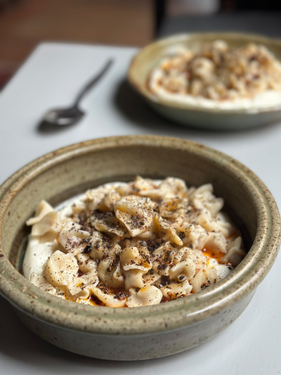 Two bowls of MANTI Turkish dumplings with yoghurt and Aleppo-spiced browned butter, served at the restaurant